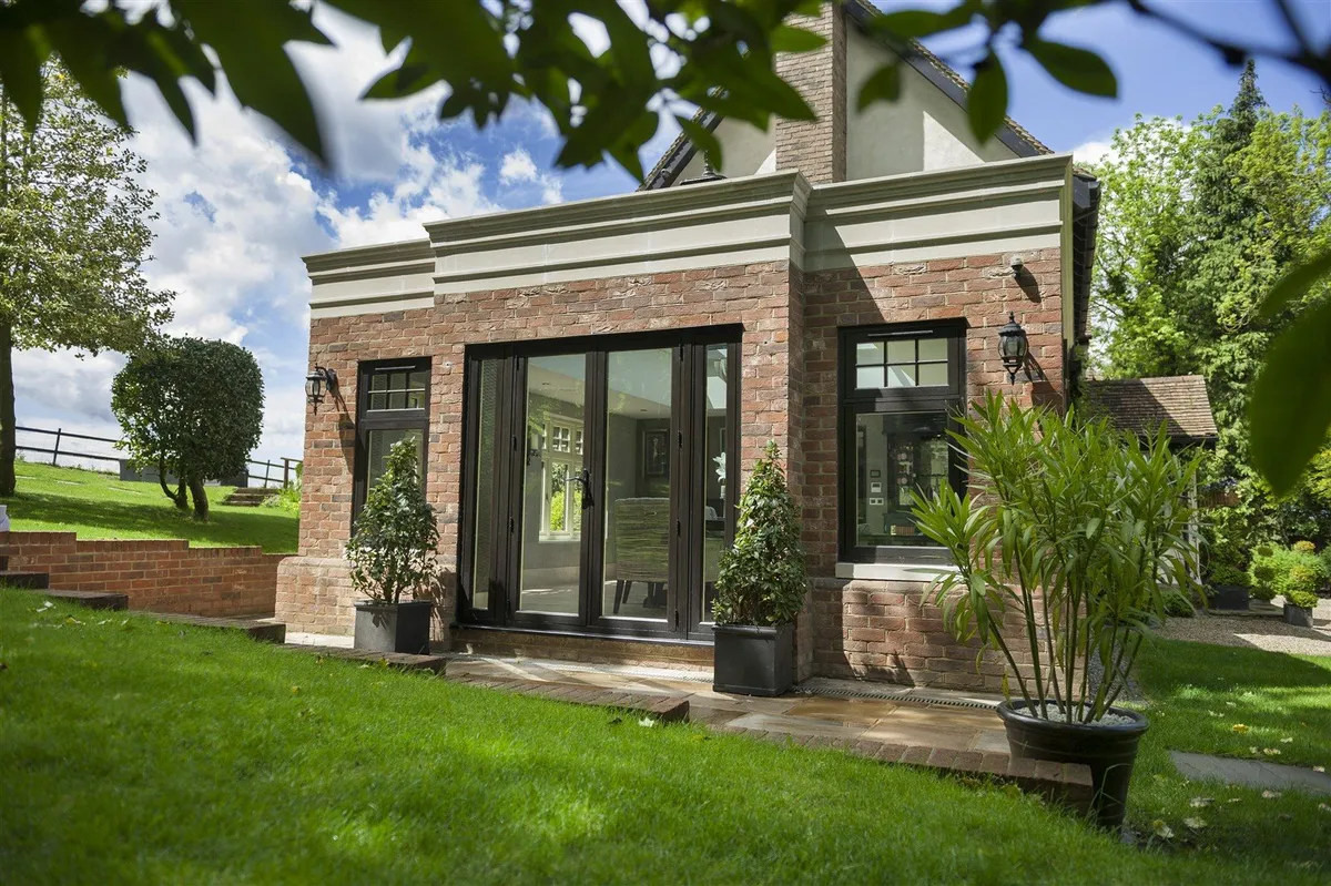 Slim dark aluminium grid doors showing a steel-look architectural route
