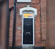 Black composite front door with a fanlight in a Victorian red-brick terrace