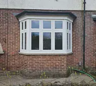 White uPVC flush casement bay window on a red-brick house