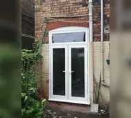 White Residence 7 French doors beneath a toplight on a painted brick wall