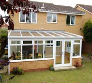 White uPVC lean-to conservatory with a glass roof on the back of a brick house