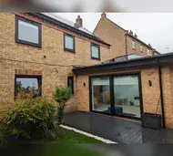 Anthracite sliding doors and windows on a modern brick extension