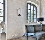Arched black steel window with slim glazing bars in a plastered living room