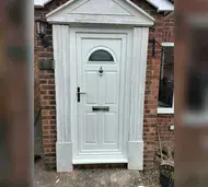 White uPVC front door with a glazed top panel in a pillared entrance surround